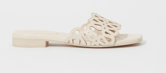 SIMKHAI Mccall laser cut cream leather flat slide sandal 
side view showing strap detail scalloped edge 
perforations and cream leather insole